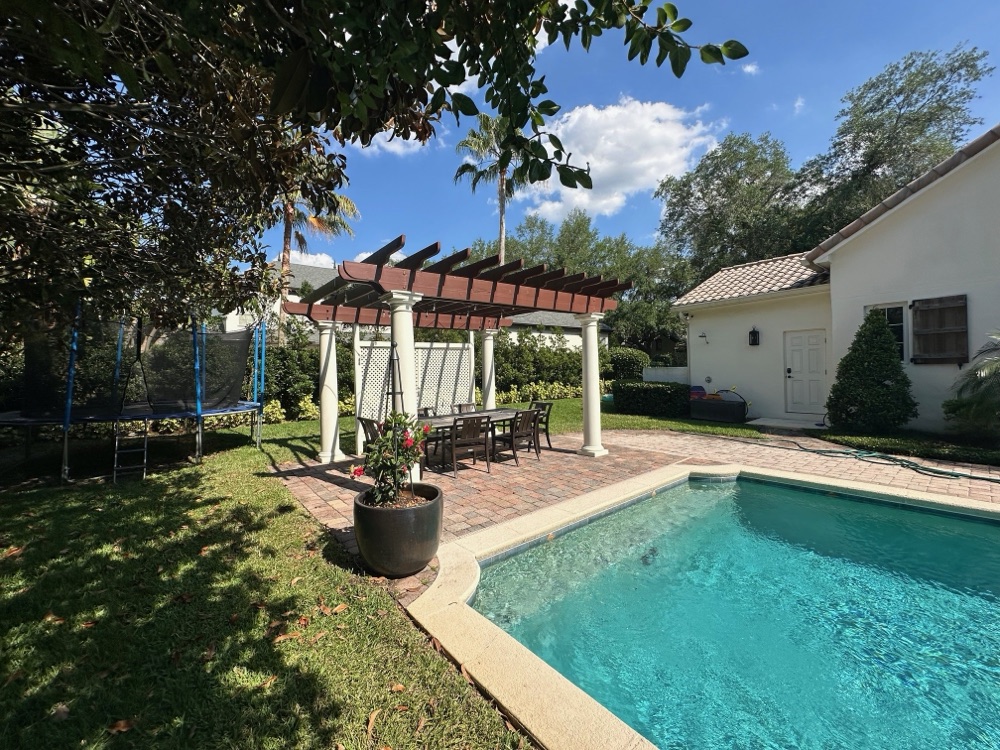Brick patio to travertine deck + raised spa — before, view 1