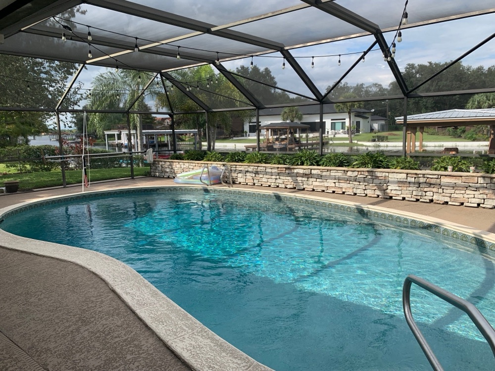 Lakefront resurface + travertine deck + fire bowls — before, view 1