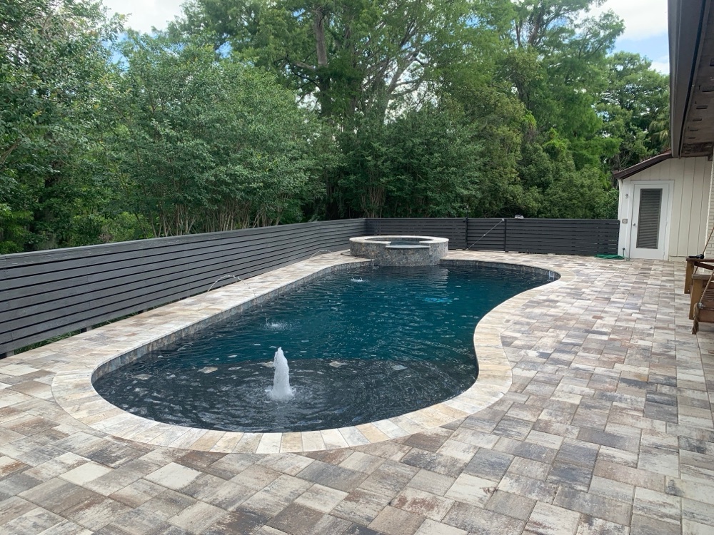Brick coping to dark resurface + travertine deck — after, view 3