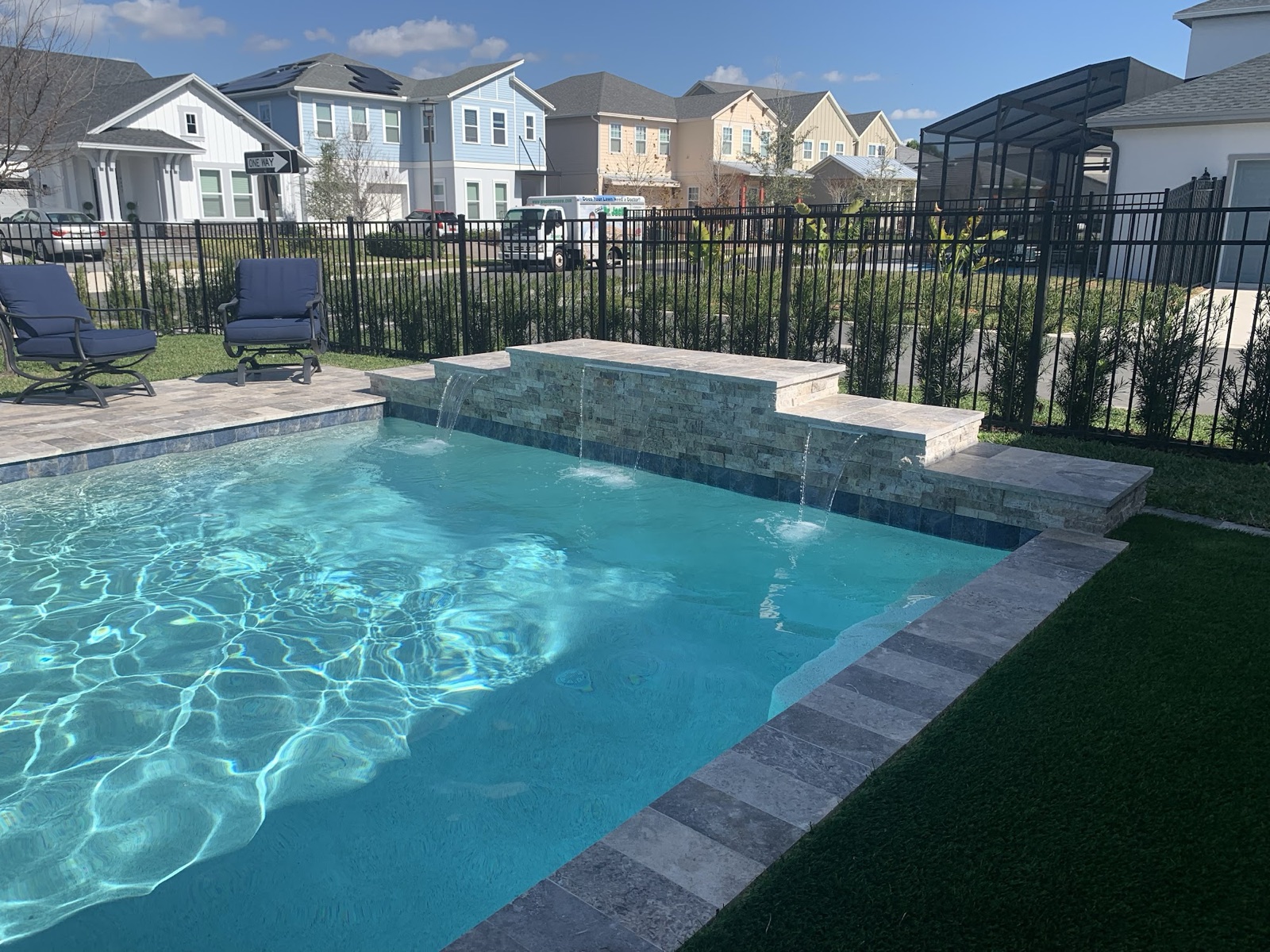 A finished Next Level pool with a raised spa and sheet-waterfall spillover — the kind of result we build toward, project after project