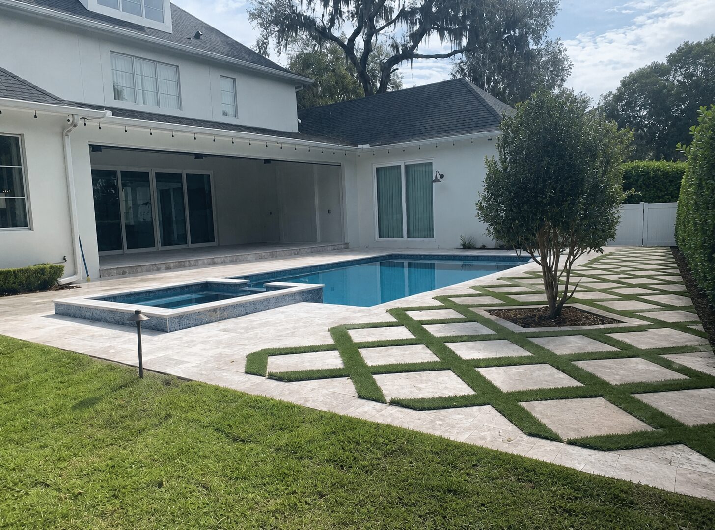 Pool with travertine deck and turf inlay detail